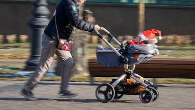A reveller wearing a festive hat runs with a pram during a parade to celebrate the upcoming Christmas and New Year in Almaty, Kazakhstan. Shamil Zhumatov / Reuters