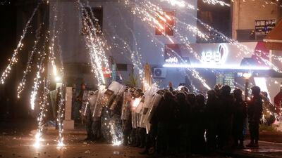 Fireworks are set off in front of police officers standing in postion behind riot shields during a protest at the Corniche al Mazzraa in Beirut, Lebanon. Reuters