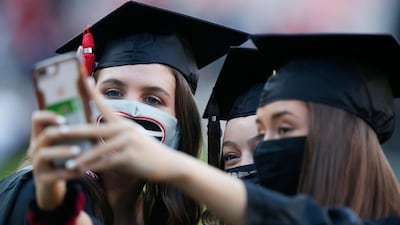 Graduates take a selfie before the start of the University of Georgia's rescheduled Spring Commencement at Sanford Stadium in Athens, Ga., Friday, Oct. 16, 2020. The ceremony was moved from the spring due to the ongoing COVID-19 pandemic. (Joshua L. Jones/Athens Banner-Herald via AP)