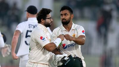 Pakistan's Abdullah Shafique, right, and Imam-ul-Haq bumps their thumbs as they walk off the field on the end of play of the second day of the first test cricket match between Pakistan and England, in Rawalpindi, Pakistan, Friday, Dec. 2, 2022. (AP Photo / Anjum Naveed)
