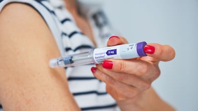 A woman injects herself with a Mounjaro pen in a bid to lose weight. Getty Images