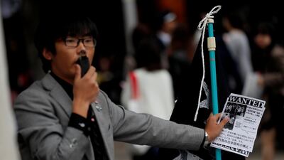A man speaks on a loudspeaker with leaflets denouncing South Korean boy band BTS outside Tokyo Dome where the band's concert is planned to be held. Kim Kyung-Hoon / Reuters
