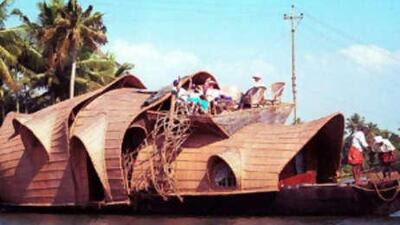 Tourists gather on a houseboat to sunbathe and observe life in the backwaters in southern India.
