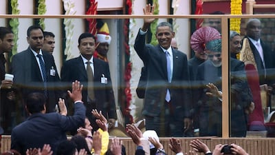 Mr Obama, left, and Indian prime minister Narendra Modi, right, wave to spectators during Republic Day celebrations. Rain failed to dampen spirits at the parade. Roberto Schmidt/AFP Photo
