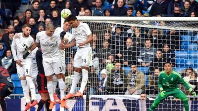 Real Madrid’s defender Sergio Ramos, Real Madrid’s Portuguese defender Pepe, Real Madrid’s Portuguese forward Cristiano Ronaldo and Real Madrid’s Brazilian midfielder Casemiro jump as they form a defensive wall in front of Real Madrid’s Costa Rican goalkeeper Keylor Navas during the Spanish league football match Real Madrid CF vs Celta de Vigo at the Santiago Bernabeu stadium in Madrid on March 5, 2016. AFP / GERARD JULIEN