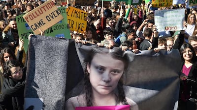 People hold placards and a banner showing political activist Greta Thunberg, in a protest against global warming in Rome. AFP
