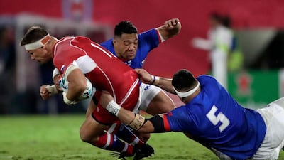 Russia's Dmitry Gerasimov is tackled by Samoa's Kane Le'aupepe, right, and Motu Matu'u. AP