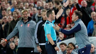 Sevilla manager Eduardo Berizzo, right, is sent to the stands by referee Danny Makkelie as his Liverpool counterpart Jurgen Klopp reacts. Jason Cairnduff / Reuters