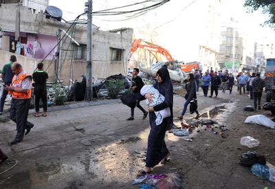 People walk past debris in a street at the site of Israeli air strikes, in Gaza City. Reuters
