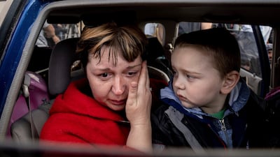 Natalia Pototska, 43, cries as her grandson Matviy looks on in Zaporizhzhia. AP