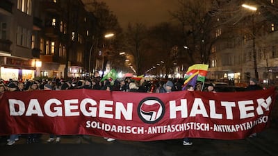 People hold a banner while attending a vigil for the victims of a shooting by a far-right extremist that left several people dead in Hanau, near Frankfurt, Germany. REUTERS/Christian Mang