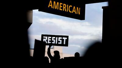 A protester on January 29 holds up a sign during a protest of President Donald Trump's executive order banning travel to the US by citizens of Iraq, Syria, Iran, Sudan, Libya, Somalia and Yemen at Philadelphia International Airport. Corey Perrine / AP