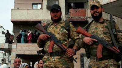 Armed members of Syrian government security forces and civilians gather to commemorate the seventh anniversary of the chemical attack for the first time after the fall of the Assad government in the town of Douma. AP