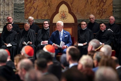King Charles sits on a chair bearing his coat of arms that was made for him by Vatican craftsmen as he became a Royal Confrater of the Abbey of St Paul. Reuters.