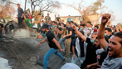 Protesters pull down concrete walls outside the governor's building in Basra. AP Photo