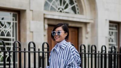A guest wearing a blue white striped button shirt, ripped denim jeans outside Anya Hindmarch on day 3 of the London Fashion Week February 2017. Christian Vierig / Getty Images