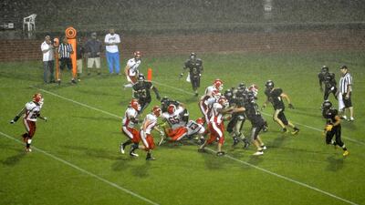 The Abu Dhabi Wildcats and Dubai Stallions play in the rain at the EAFL Desert Bowl on Friday night. Charles Crowell for The National / March 14, 2014