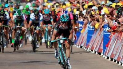 Belgium’s Jan Bakelants grits his teeth just ahead of the finish line as the peloton looms large behind him on Stage 2 of the Tour de France.