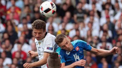 Germany forward Thomas Muller, left, heads the ball with Slovakia defender Milan Skriniar. Kenzo Tribouillard / AFP
