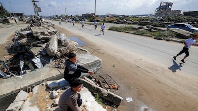 Boys sitting on rubble watch the event.