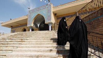 Women, wearing protective face masks, walk down the stairs amid the coronavirus disease (COVID-19) outbreak, in the holy city of Najaf, Iraq. Reuters