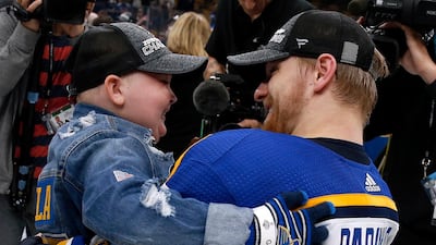 St. Louis Blues Colton Parayko lifts young fan Laila Anderson, left, while the team celebrated on the ice after the Blues defeated the Boston Bruins in Game 7 of the NHL Stanley Cup Final in Boston. AP Photo