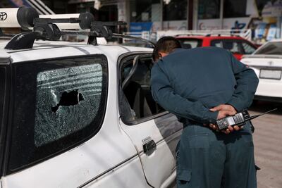 An Afghan policeman inspects the car in which Dawa Khan Menapal was shot dead in Kabul. AP Photo