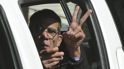 EgyptAir plane hijacking suspect Seif Eddin Mustafa flashes the victory sign as he leaves a court in a police car after a remand hearing as authorities investigate him on charges including hijacking, illegal possession of explosives and abduction in the Cypriot coastal town of Larnaca. Petros Karadjias / AP Photo