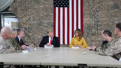 US President Donald Trump, flanked by National Security Adviser John Bolton, first lady Melania Trump and US Ambassador to Iraq Doug Silliman, meets political and military leaders during an unannounced visit to Al Asad Air Base, Iraq. Reuters
