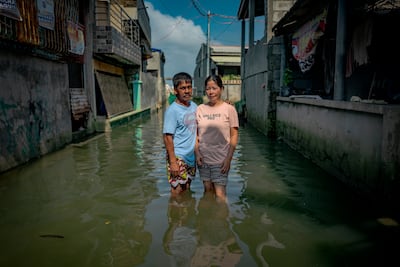 Rolando Laudiangco and his wife Bernadette stand in floodwaters outside their home. Getty Images