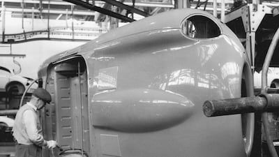 A worker touches up the paintwork on an E-Type body shell at the company's Coventry works in 1961. Getty Images