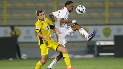 Wasl's Emiliano Alfaro, left, and Juma Abdulla of Al Jazira contest a bouncing ball. Jake Badger for The National