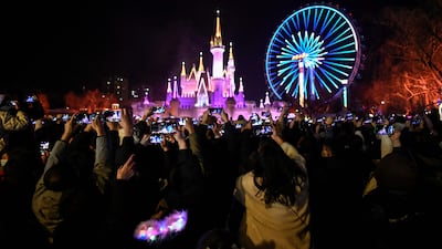 People wearing masks attend a New Year's countdown at an amusement park in Beijing. AFP
