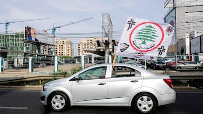 A Lebanese supporter of the Christian Lebanese Forces party drives a car flying their flag along the Dbayeh highway between the coastal city of Jounieh and the capital Beirut. Joseph Eid / AFP