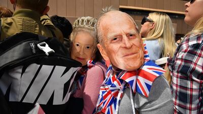 Royal fans wearing face masks of Queen Elizabeth and Prince Philip at the Sydney Opera House. EPA