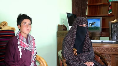 Qamar Gul, 16, right, and her brother Habibullah, 12, pose for photograph in the governor's office in Feroz Koh, the provincial capital of Ghor province. AP