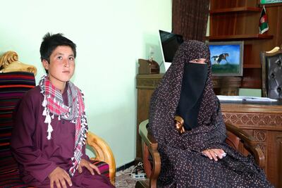 Qamar Gul, 16, right, and her brother Habibullah, 12, pose for photograph in the governor's office in Feroz Koh, the provincial capital of Ghor province. AP