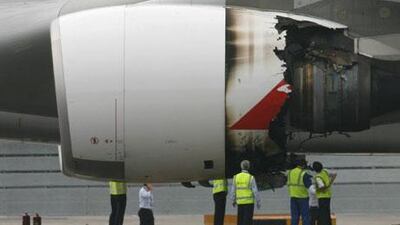 Technicians inspect the damaged engine of a Qantas Airways A380 passenger plane after it was forced to make an emergency landing at Changi airport in Singapore.