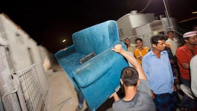 Workers from Take My Junk carry a couch in to Abou Seif labour camp. Take My Junk donates unwanted goods to labourers.