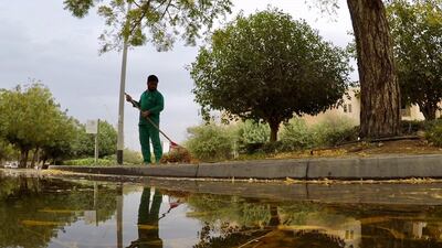 A man cleaning the garden area at the Gardens in Dubai after the rain. Pawan Singh/The National