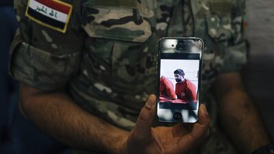 An Iraqi army corporal who gave his name only as Saif holds a phone displaying a screenshot from a video released by ISIL that shows his brother as a captive in Erbil, Iraq. Alice Martins / AP Photo