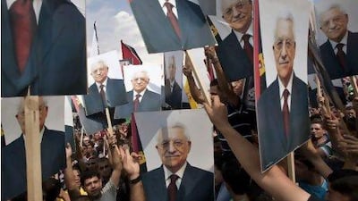 Palestinians hold pictures of President Mahmoud Abbas in the West Bank city of Ramallah as he received received a hero's welcome in the West Bank. Bernat Armangue / AP Photo