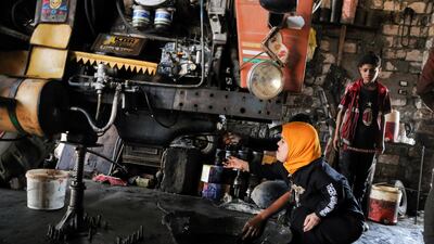 Ms Zanaty carries out an oil check on a tractor. Reuters