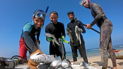 Palestinian spear-fisherman Ashraf Al-Amoudi displays fish on a beach in the southern Gaza Strip. Reuters