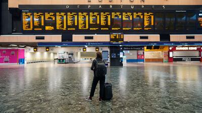 A passenger at Euston station in London looks at the departures board on the first day of a rail strike on Tuesday June 21, 2022. Britain's biggest rail strikes in decades went ahead Tuesday after last-minute talks between a union and train companies failed to reach a settlement over pay and job security. Up to 40,000 cleaners, signalers, maintenance workers and station staff are due to walk out for three days this week, on Tuesday, Thursday and Saturday. (Stefan Rousseau / PA via AP)