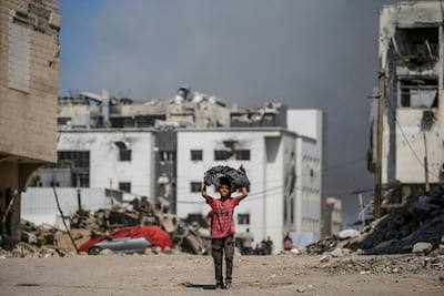 A Palestinian boy walks in the wake of an Israeli air strike near Al Shifa Hospital in Gaza city. EPA