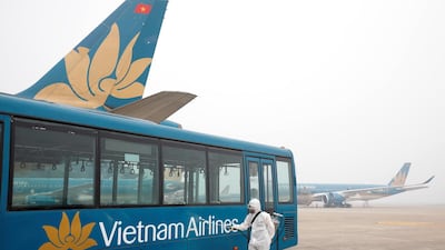 A health worker sprays disinfectant outside a bus to protect from the recent coronavirus outbreak, at Noi Bai airport in Hanoi, Vietnam. Reuters