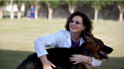 Vet Margit Gabriele Müller, the director of the Abu Dhabi Animal Shelter, with one of the shelter's rescued dogs. Silvia Razgova / The National