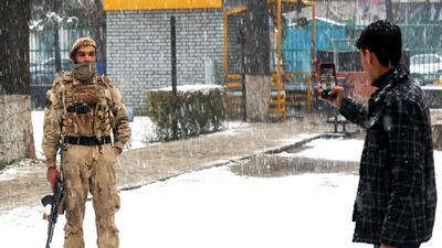 A man takes a picture of a member of the security forces in Kabul. AFP