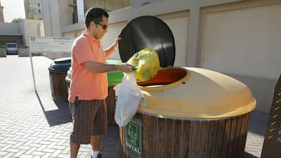 A man throws rubbish into the metal and plastic section of the recycling center at The Greens neighbourhood. Jaime Puebla / The National